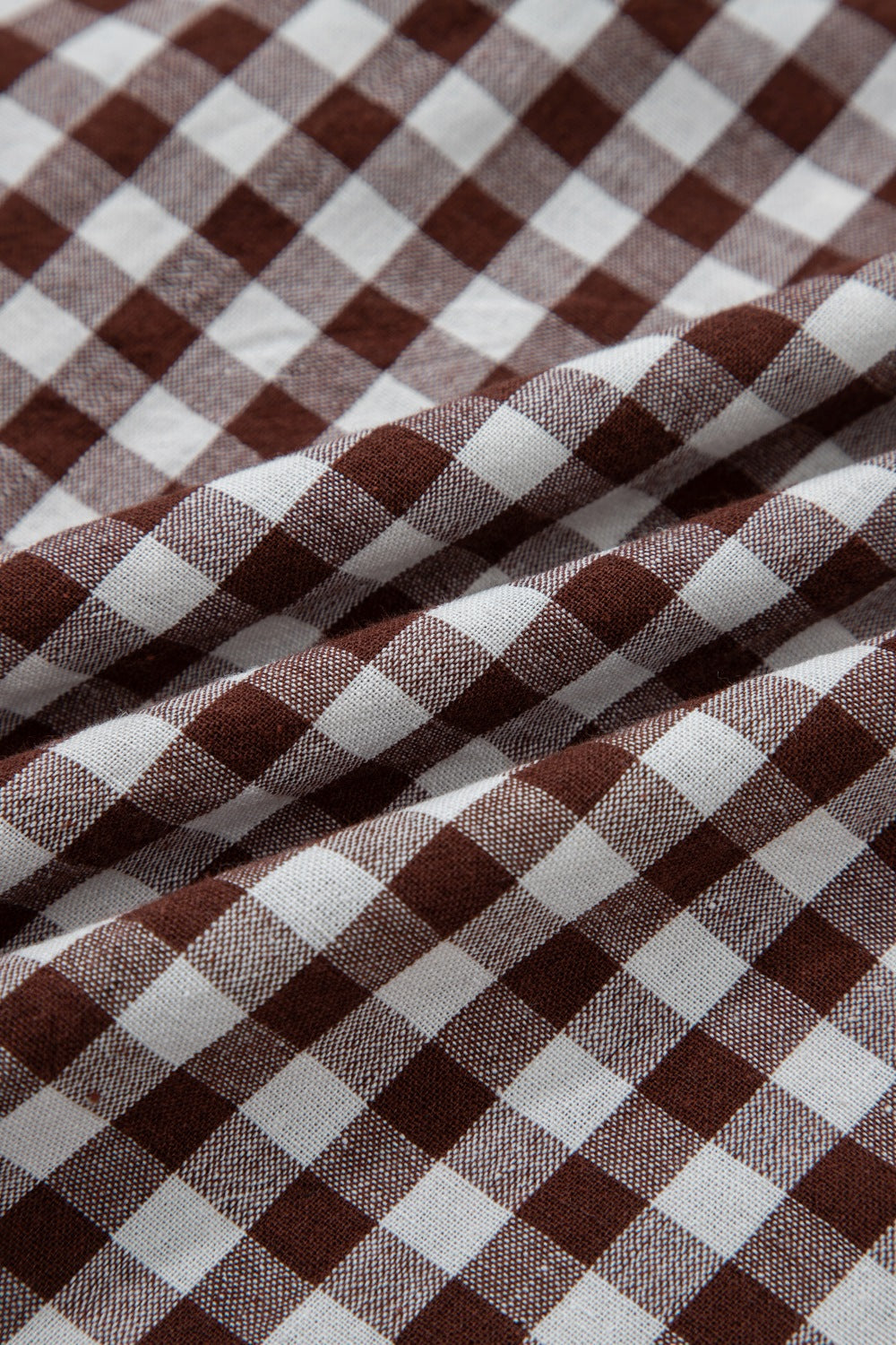 Woman wearing a gingham zip-front midi dress with zipper closure and no stretch made of 95% cotton and 5% polyester