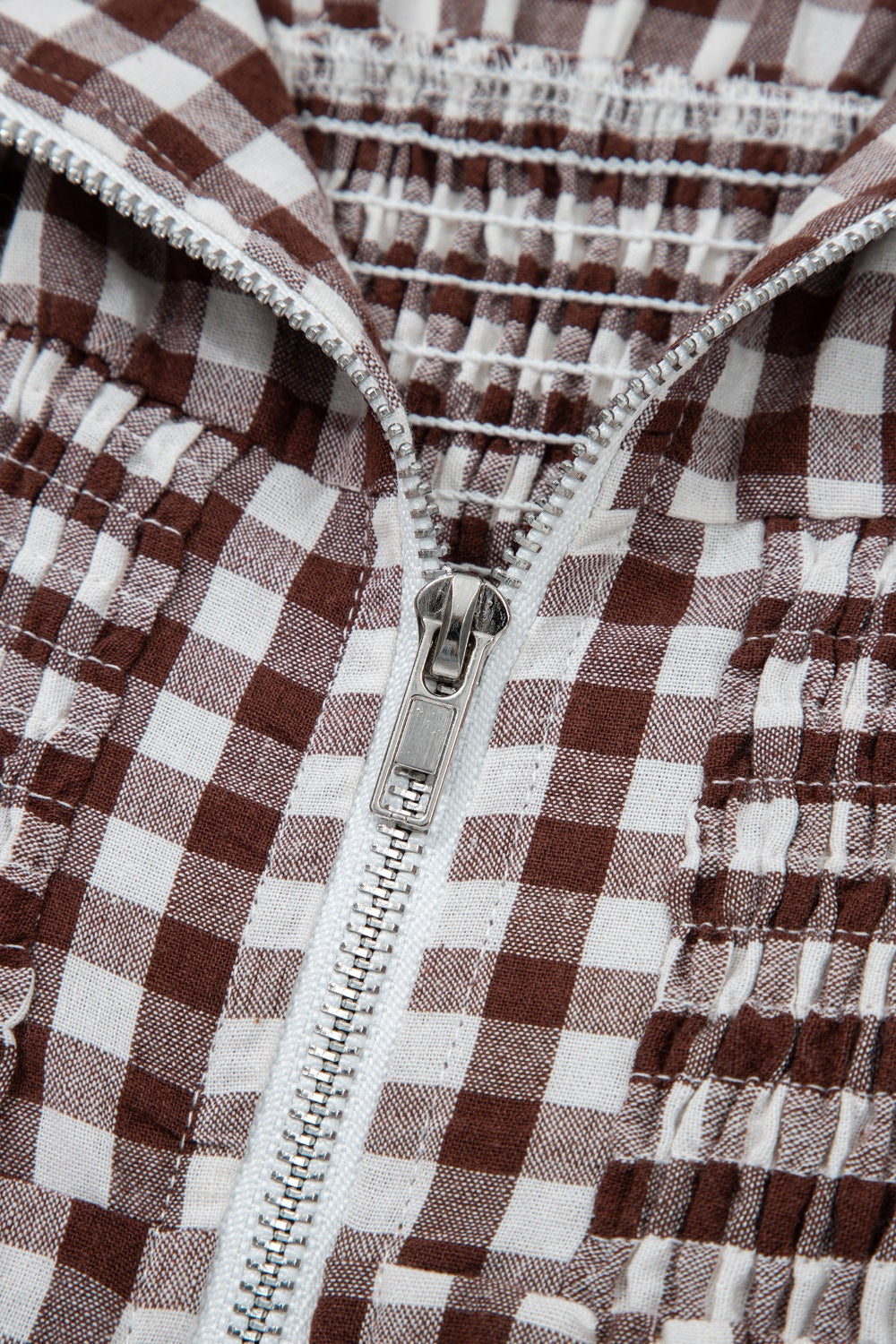 Woman wearing a gingham zip-front midi dress with short sleeves and front zipper detail