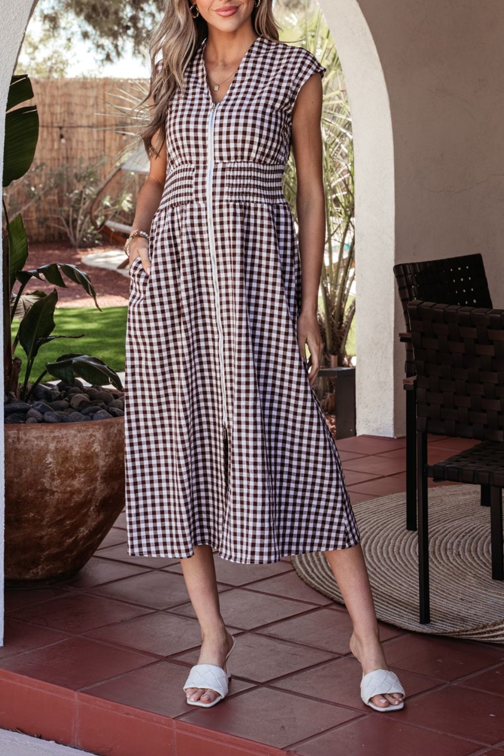 Woman wearing a gingham zip-front midi dress with no stretch and zipper detail