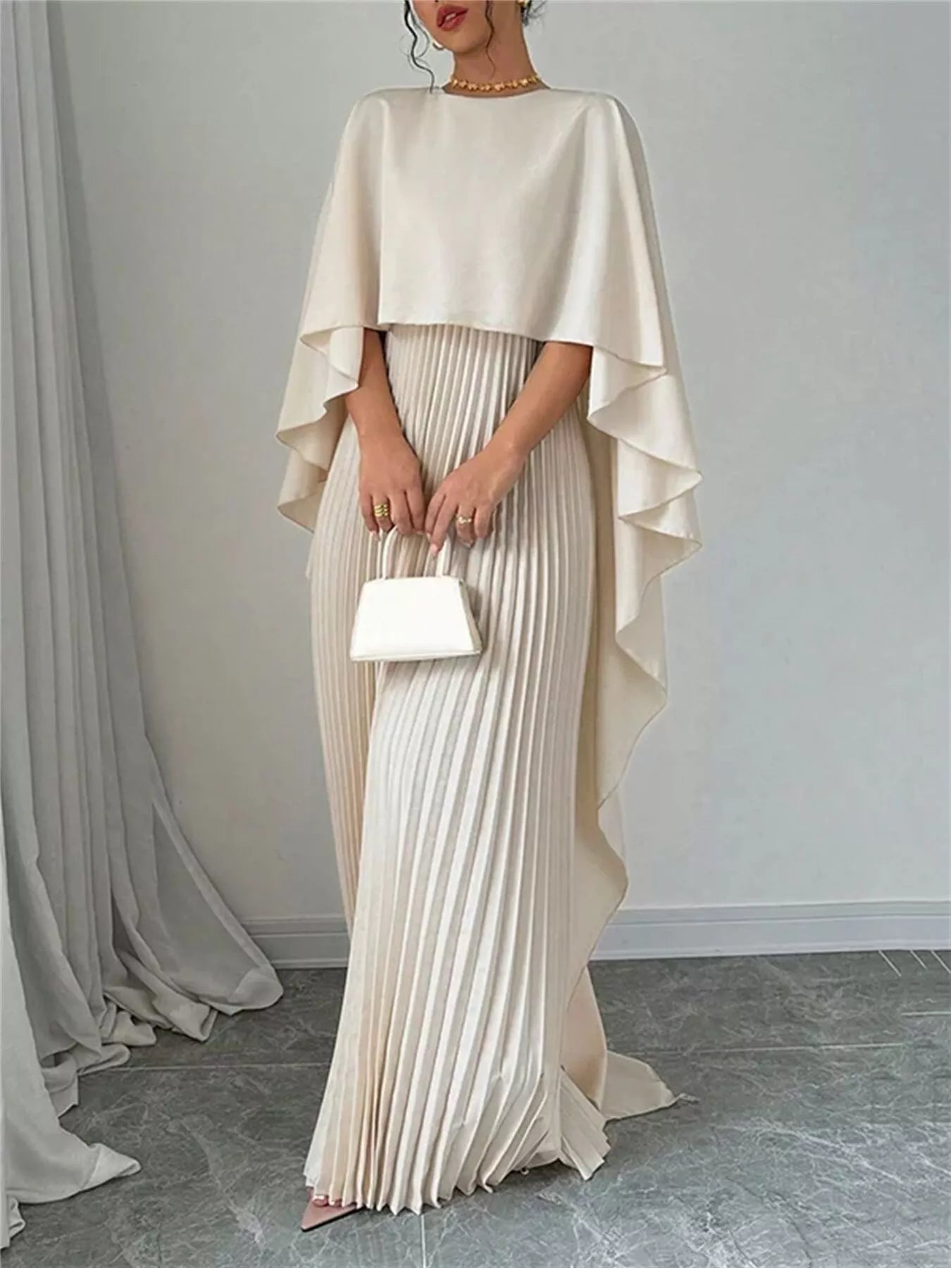 Woman wearing a black cape pleated maxi dress with no stretch and 100% polyester material