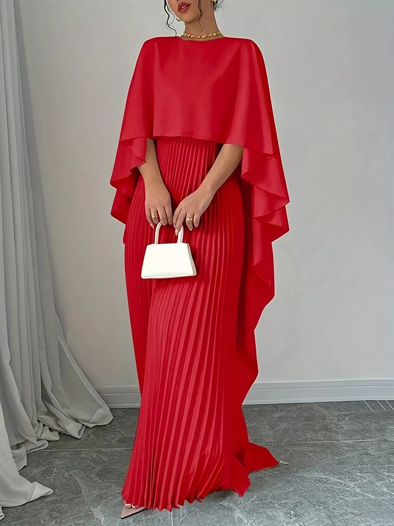 Woman wearing a sleeveless black cape pleated maxi dress made of 100% polyester, machine washable.