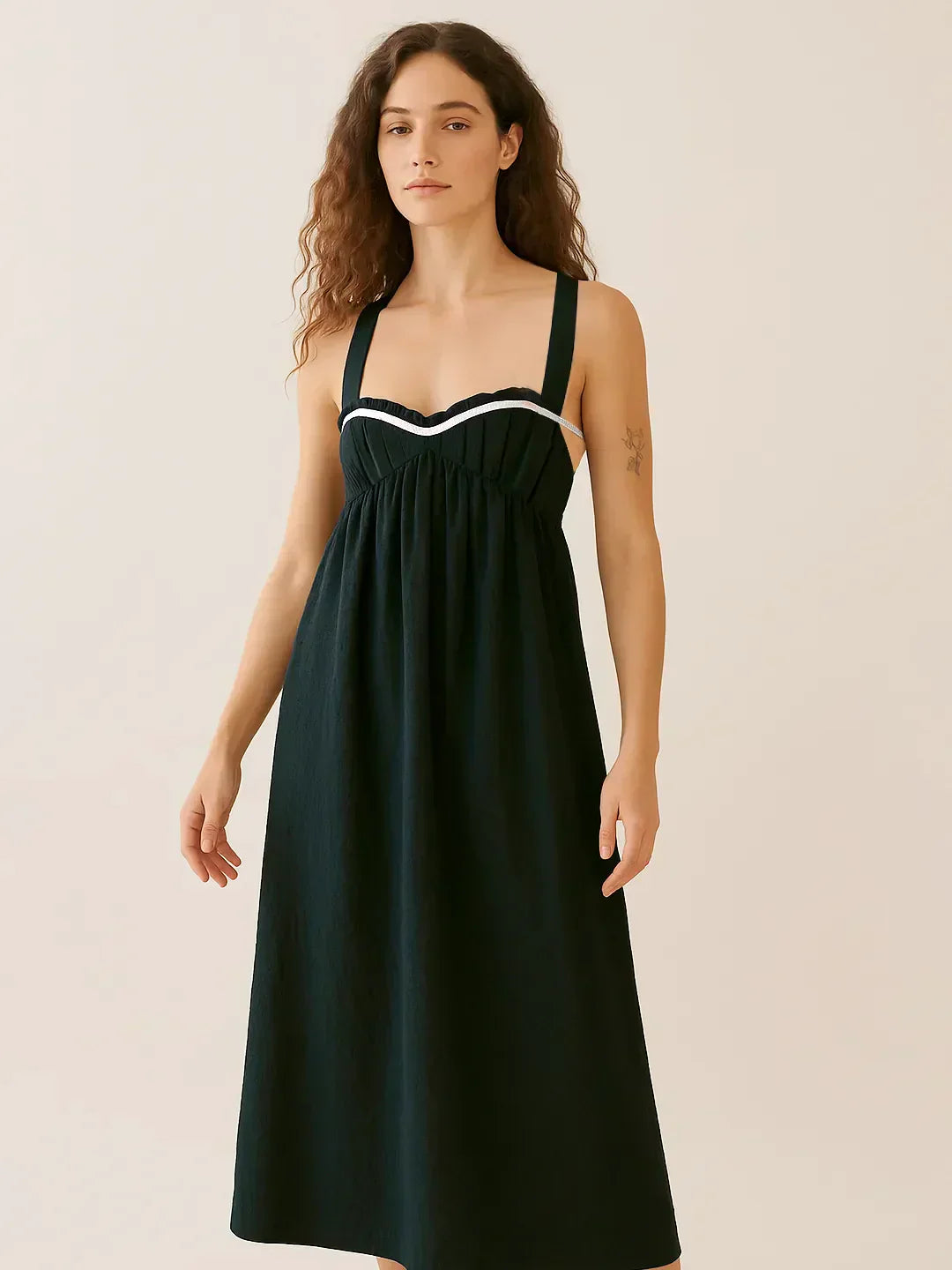Woman wearing a ruched sweetheart neck midi dress with tied details and no stretch fabric
