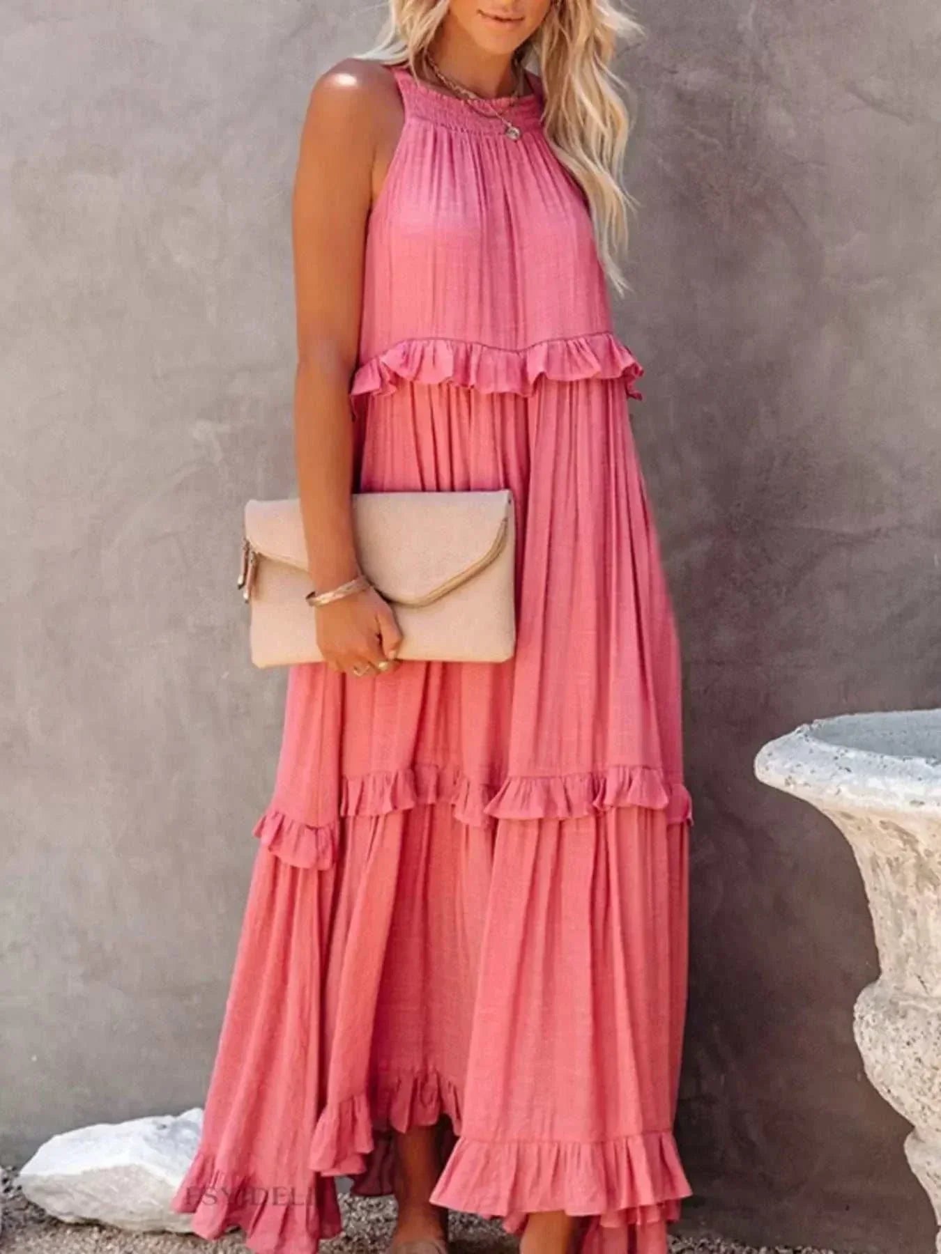 Woman wearing a ruffled tiered sleeveless maxi dress made of 100% polyester with slight stretch and tie details