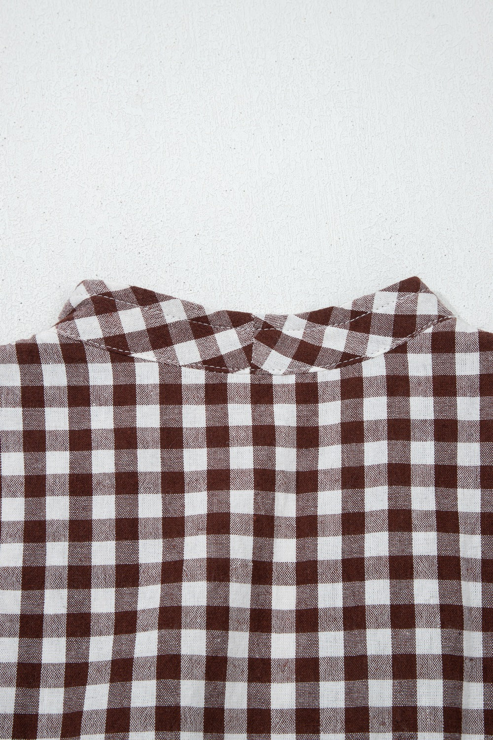 Woman wearing a gingham zip-front midi dress made of 95% cotton and 5% polyester with no stretch and machine washable care instructions