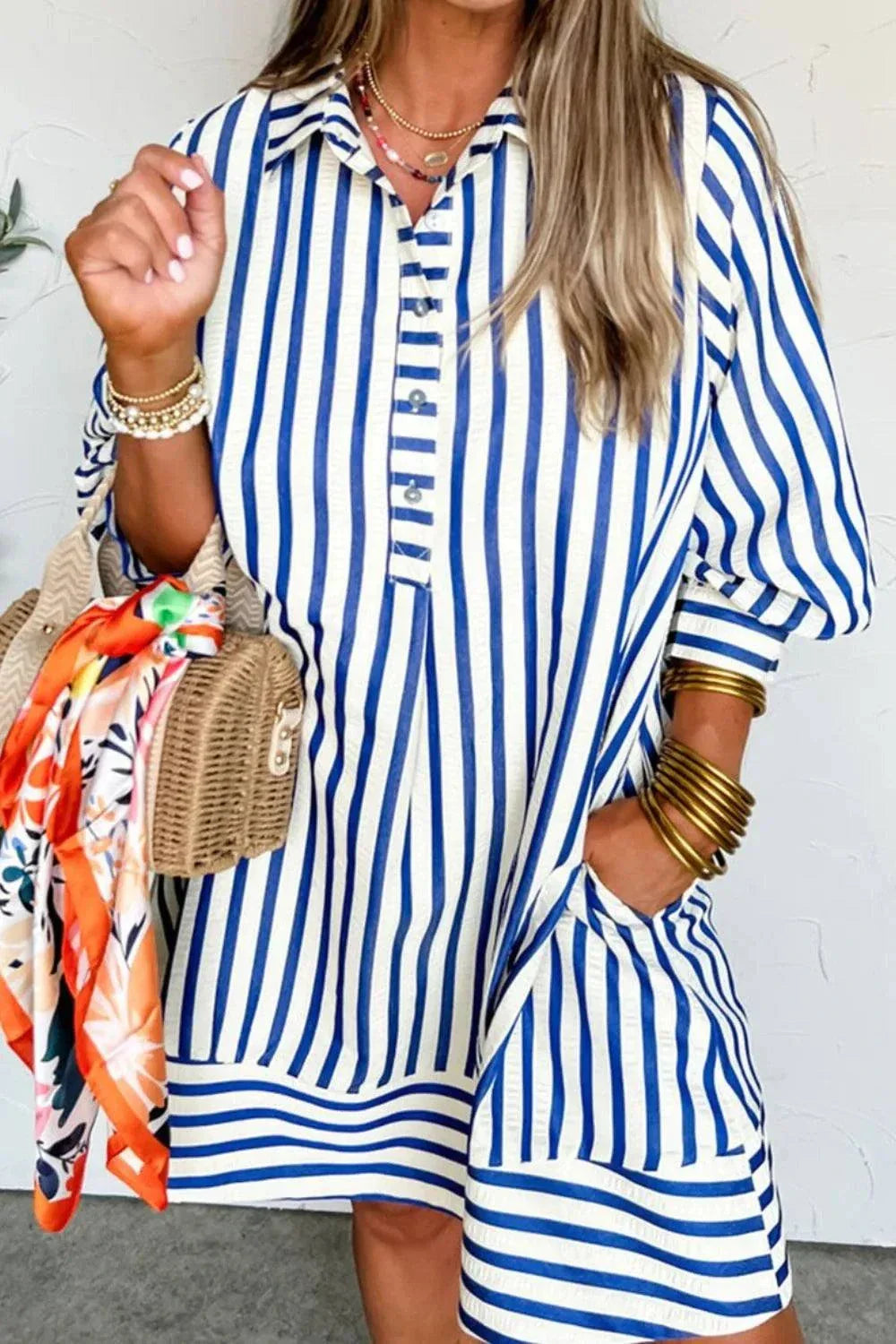 Woman wearing a striped button front dress with short sleeves and no stretch fabric
