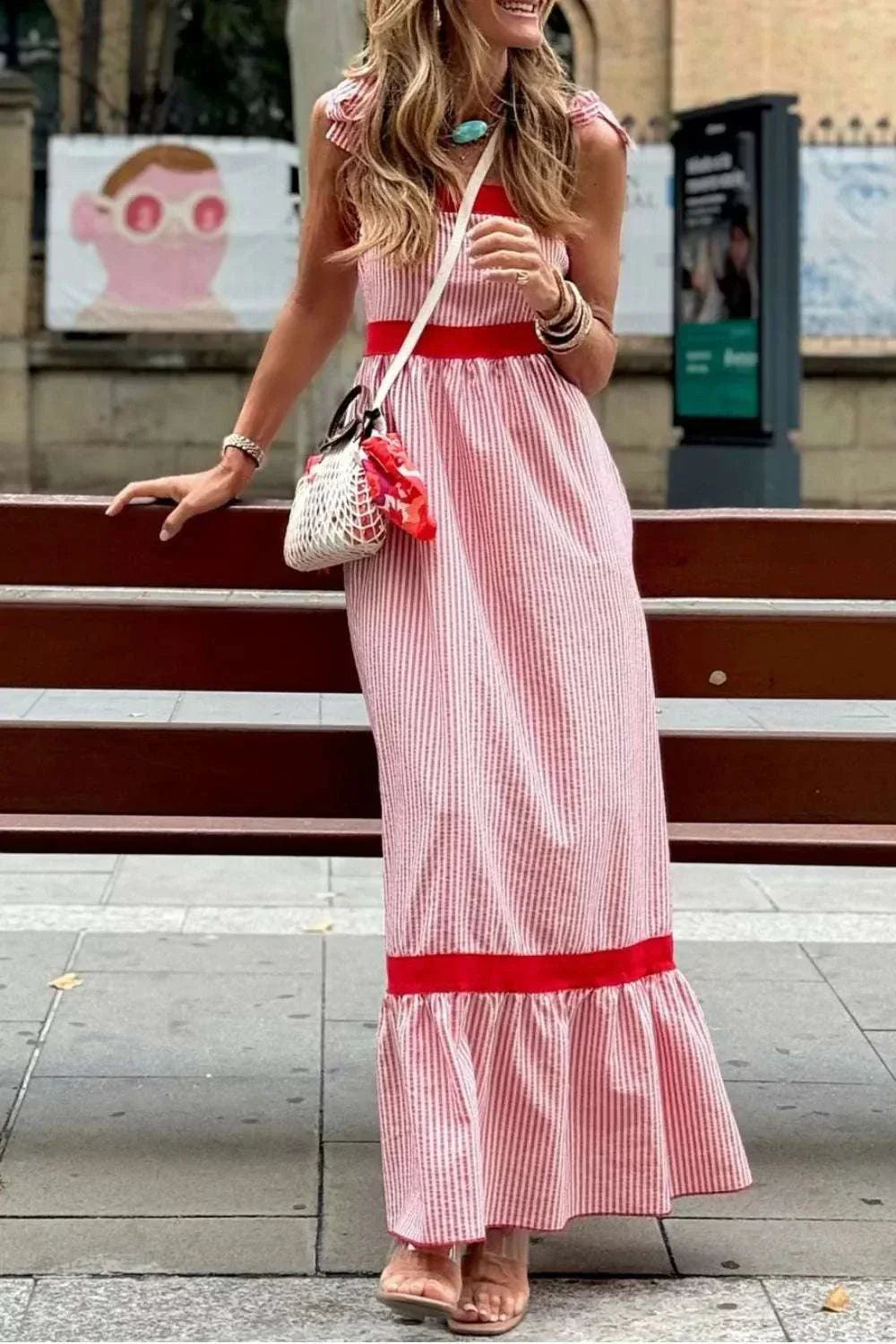Woman wearing stripe bow knot straps contrast trim high waist ruffle hem maxi dress