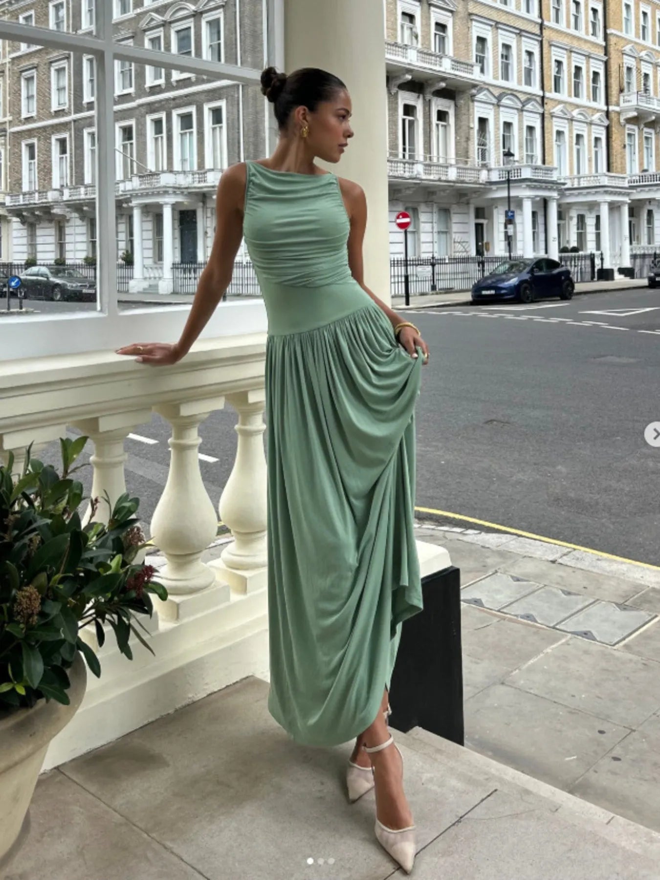 Woman wearing a ruched sleeveless maxi dress with moderate stretch and viscose fabric