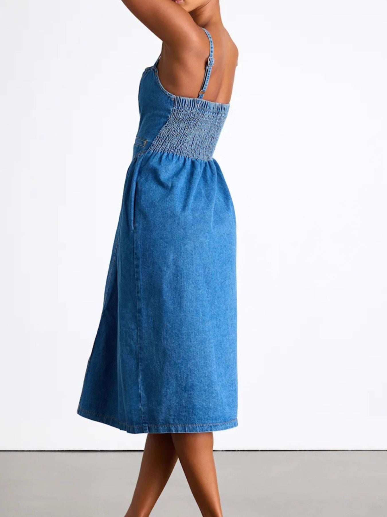 Button-front midi denim dress with smocked bodice and pockets, made of rayon and polyester blend.