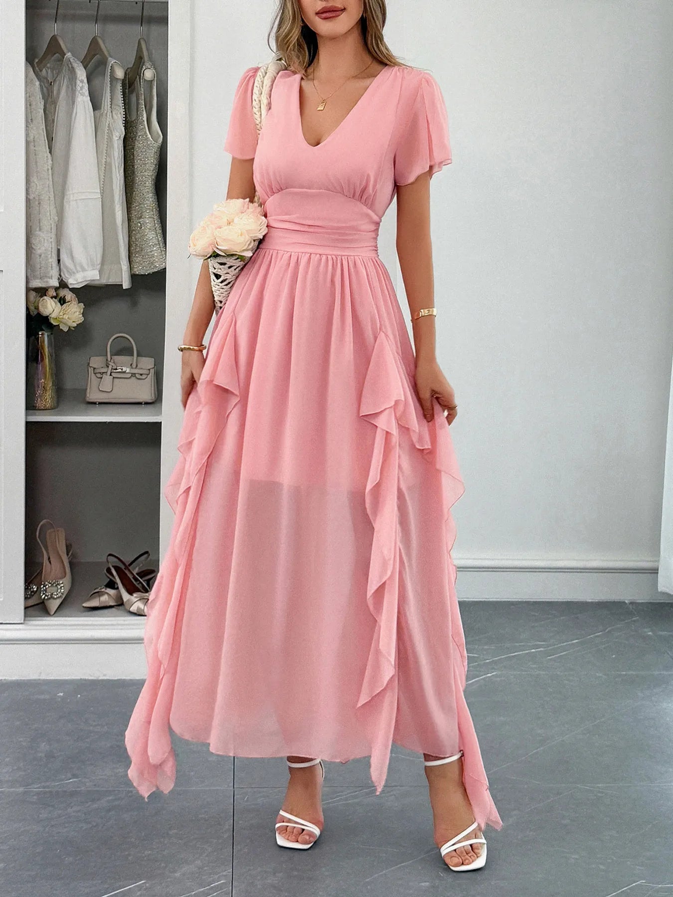 Woman wearing a ruffled V-neck flutter sleeve dress made of slightly stretchy polyester fabric