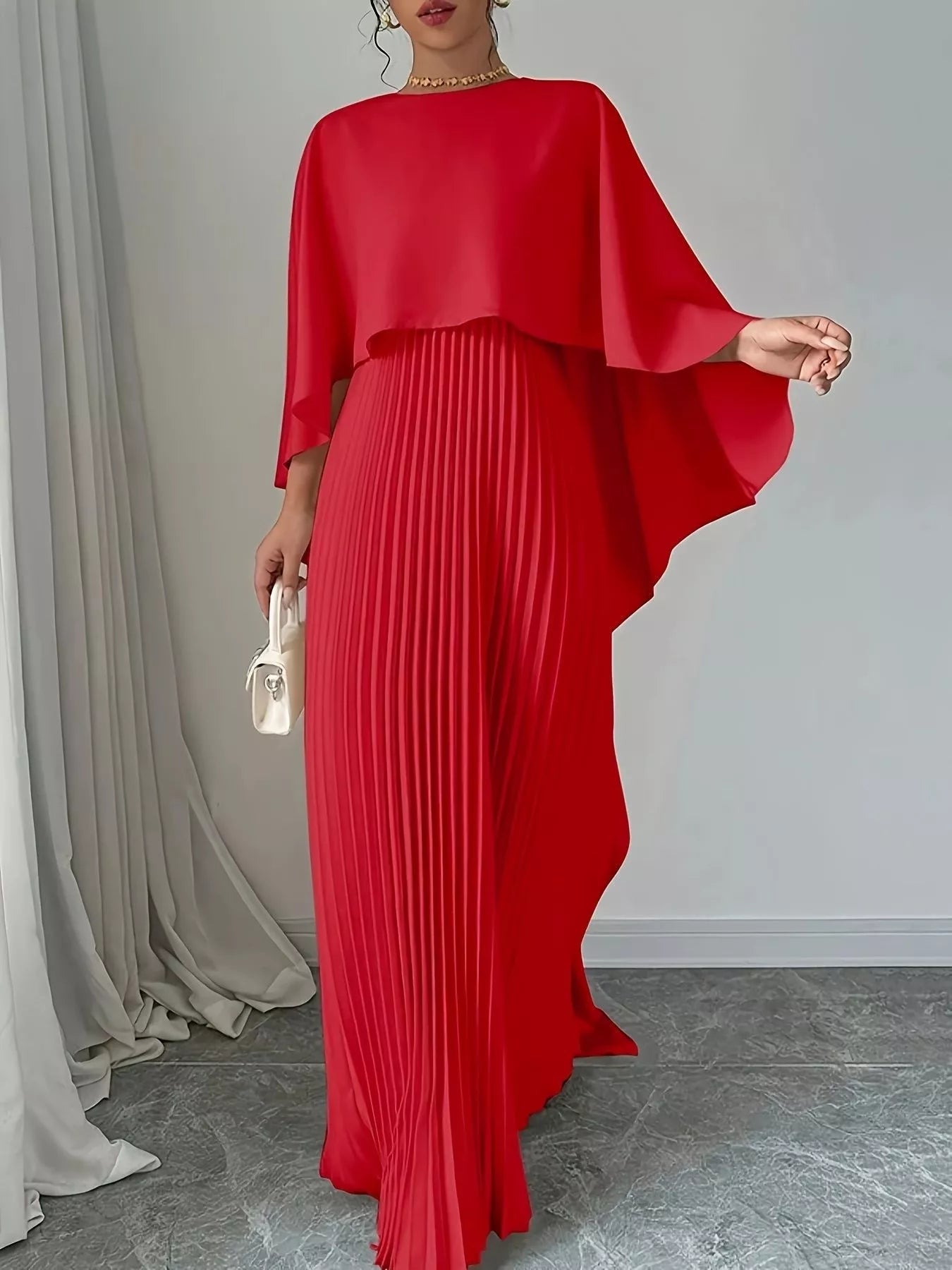 Woman wearing a black Cape Pleated Maxi Dress with pleats and no stretch material
