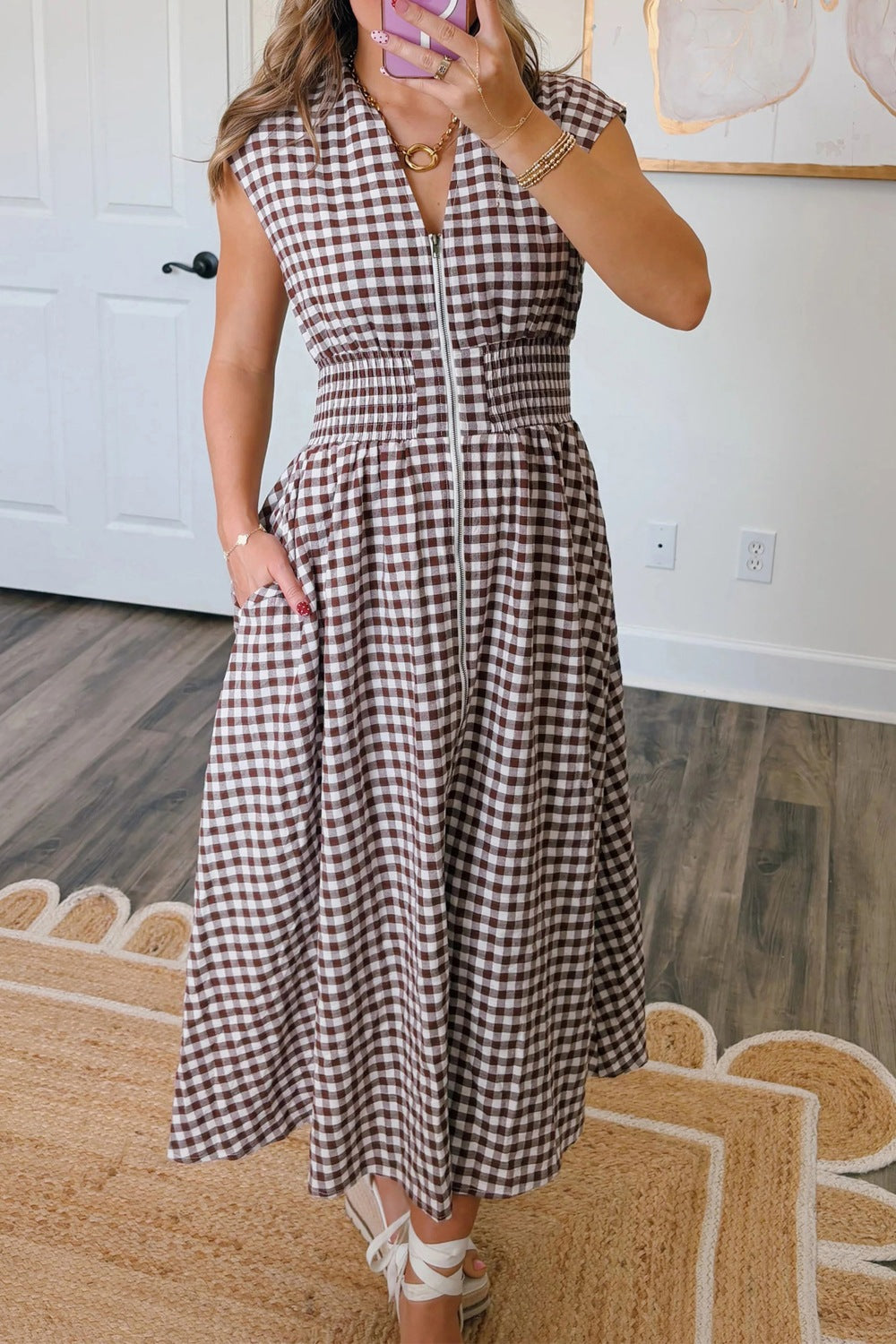 Woman wearing a gingham zip-front midi dress made of 95% cotton and 5% polyester, featuring a zipper and no stretch.