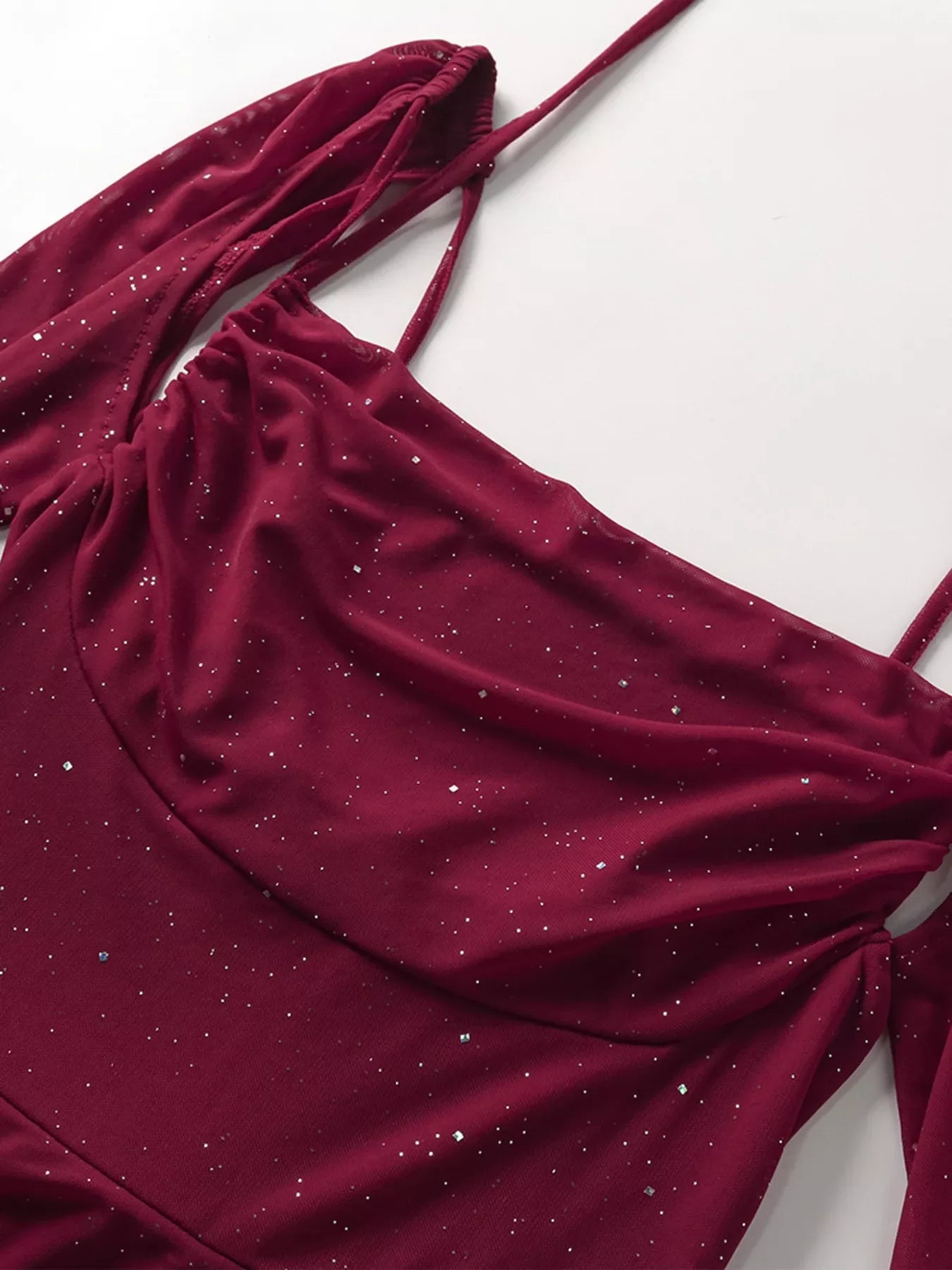 Woman wearing glitter slit maxi dress with tied waist and zipper detail