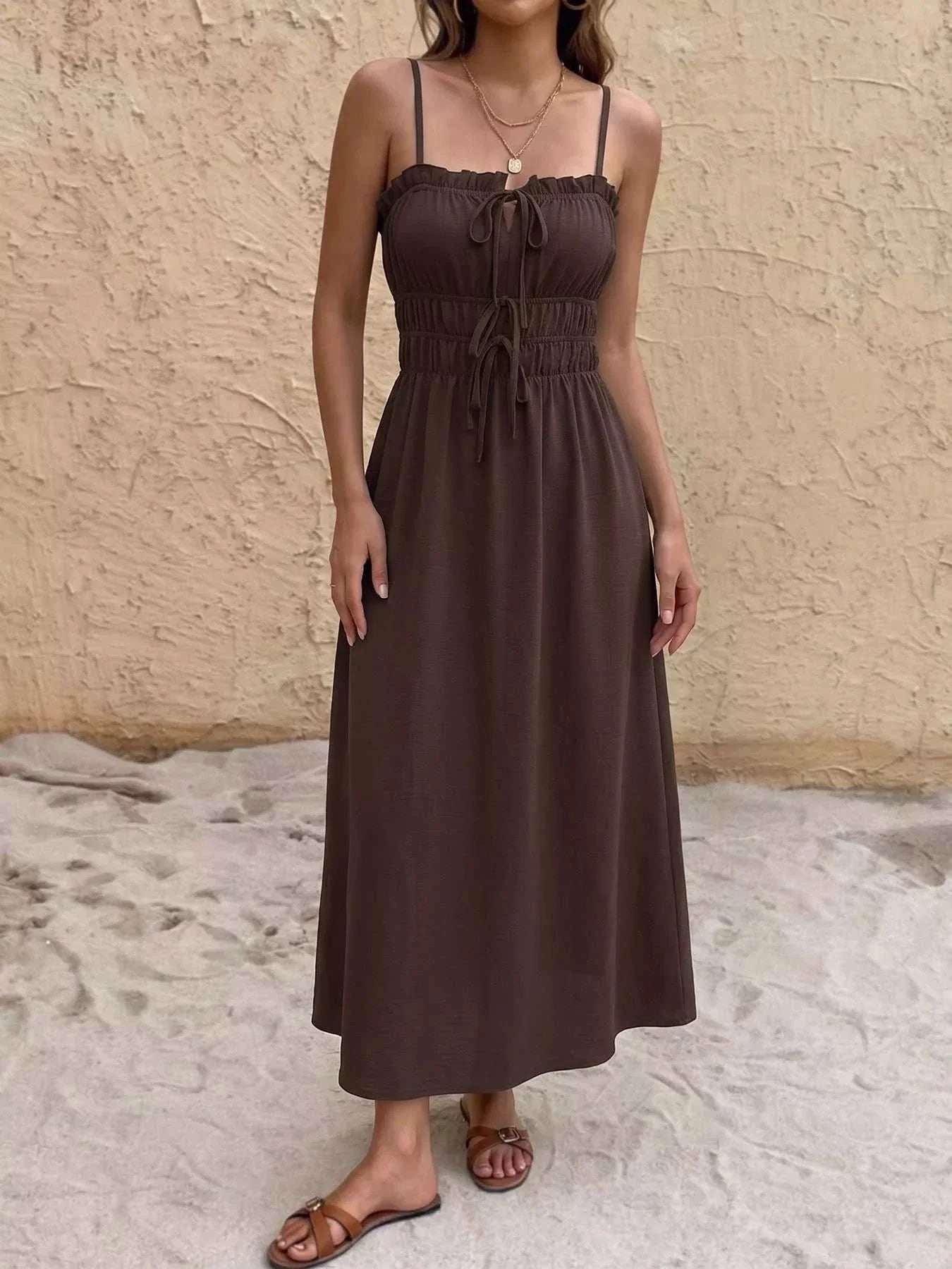 Woman wearing a smocked tie-front A-line dress with frill details, made of 100% polyester
